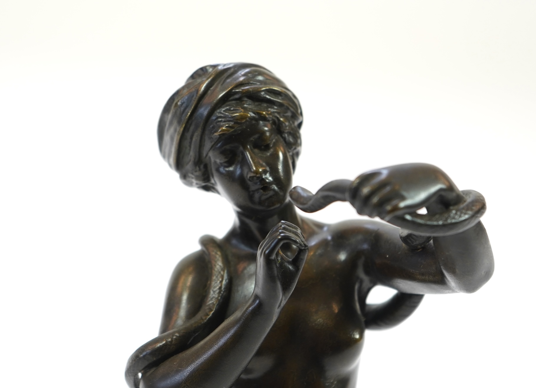 Josef Wind (German, 1864-1889). A patinated bronze of a nude female snake charmer